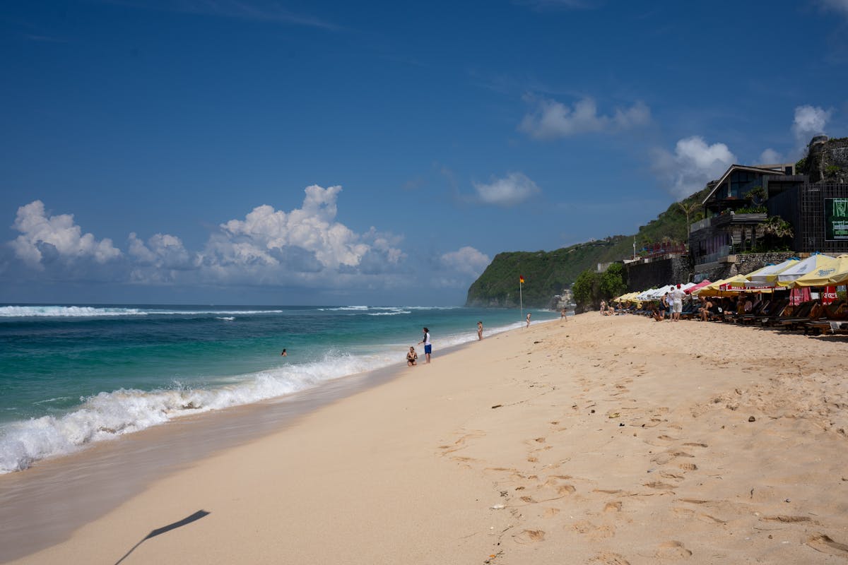 Belle plage ensoleillée sur la côte de Bali avec vagues et ciel bleu