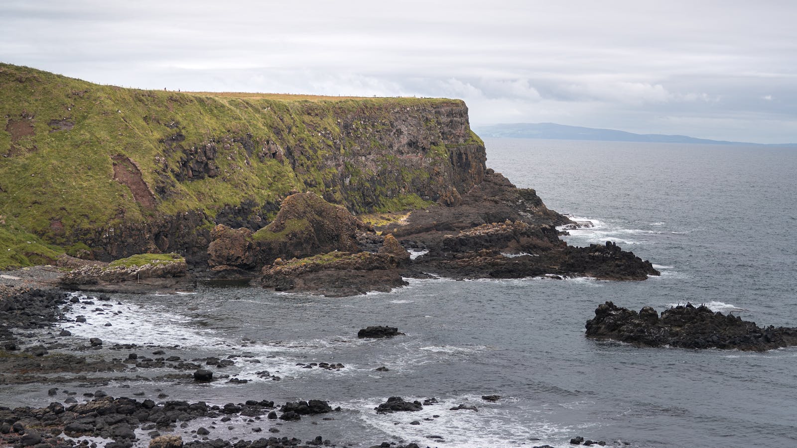 Falaises spectaculaires de la côte d'Irlande du Nord sous un ciel dramatique